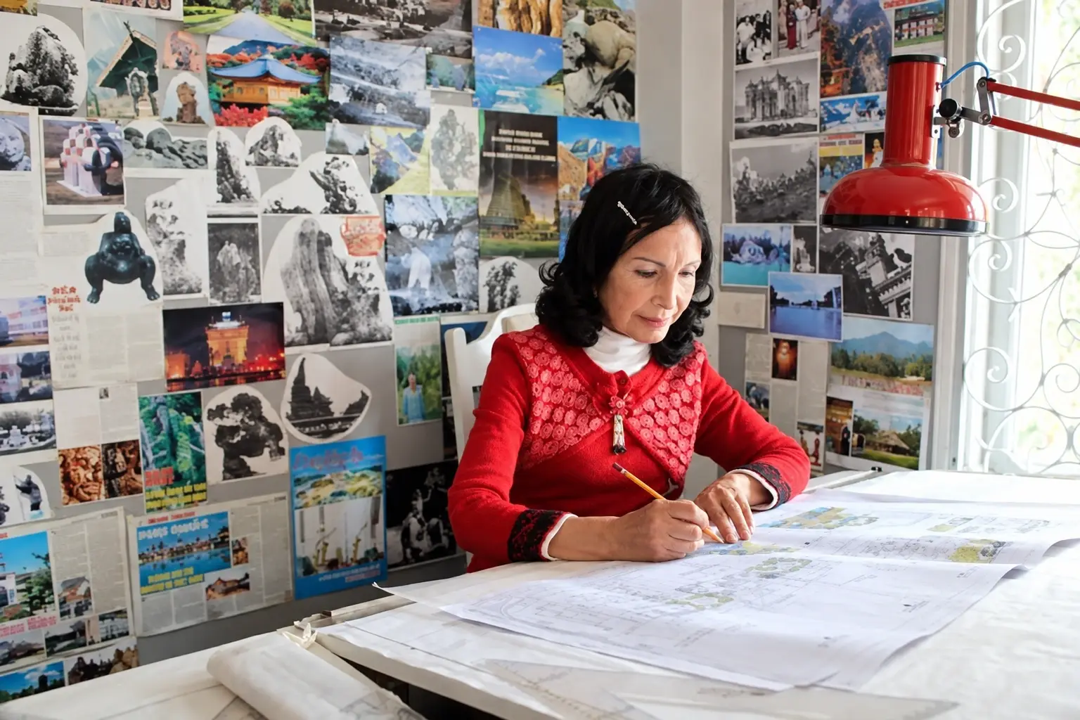 Đặng Việt Nga working on architectural drawings.